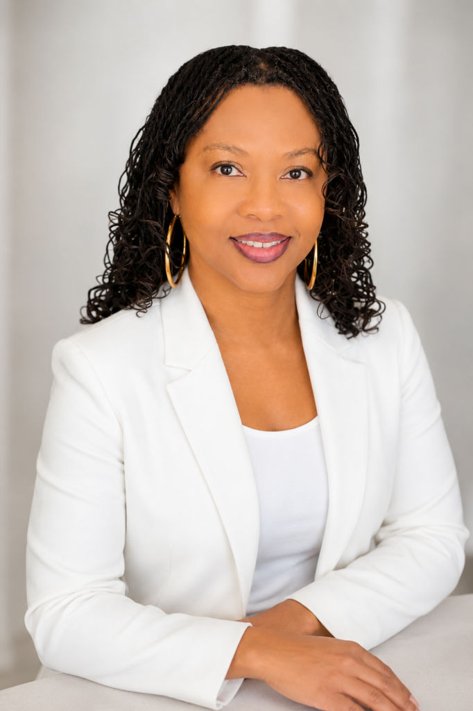 Rachel Headshot pose in white blazer with arms folded